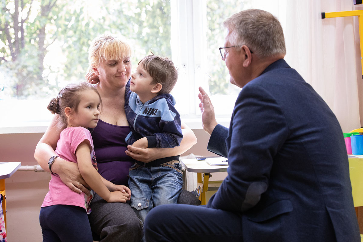 United Methodist Bishop Christian Alsted prays with Oksana and her children, Constantine and Emily, in the Onokivtsi Secondary School where they were staying near Uzhhorod, Ukraine, after Russia invaded their hometown of Kharkiv. 2022 file photo by Mike DuBose, UM News.