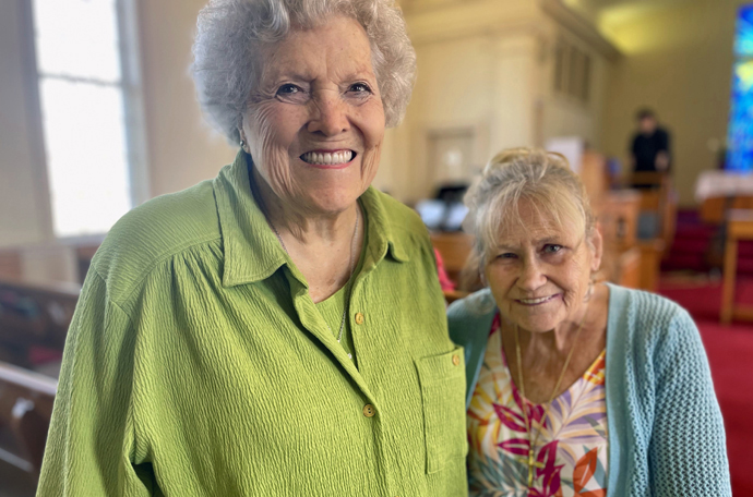 Judy Burton (right) smiles with friend Joann Mitchell in Glencliff United Methodist Church, where Mitchell was baptized several years ago in her 80s. The women of faith began leading a food program during the pandemic because they were worried about homeless people not receiving the aid to which they were accustomed. Photo courtesy of Neelley Hicks.