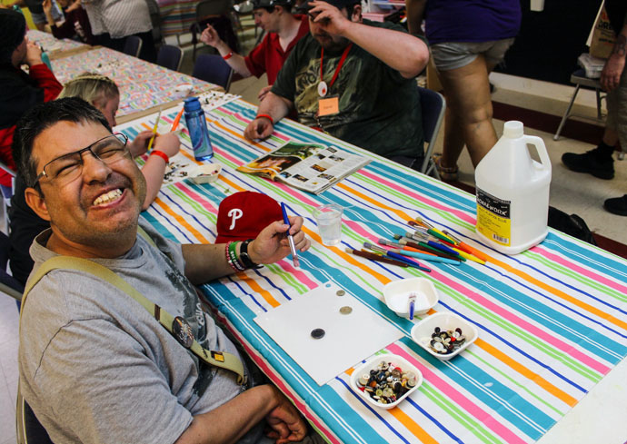 Orlando, a participant in the Challenge Camp at Innabah Camp and Retreat Center in Spring City, Pa., flashes a big grin while working on an art project in this undated photo. Innabah offers eight challenge camps each summer for developmentally delayed adults over 18. Photo by Camp Innabah staff.