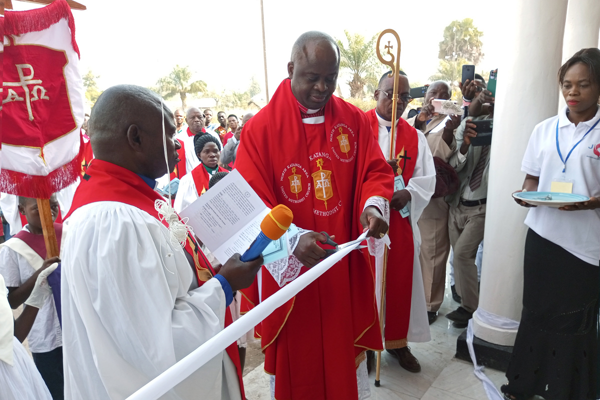 Bishop Mande Muyombo cuts the ribbon at the dedication of Banza Kaluwashi United Methodist Church in Kabalo, Congo, in June. The church is named after a Congolese lay missionary and former slave who planted churches in the region in the early 1900s. Photo by Betty Kazadi Musau.