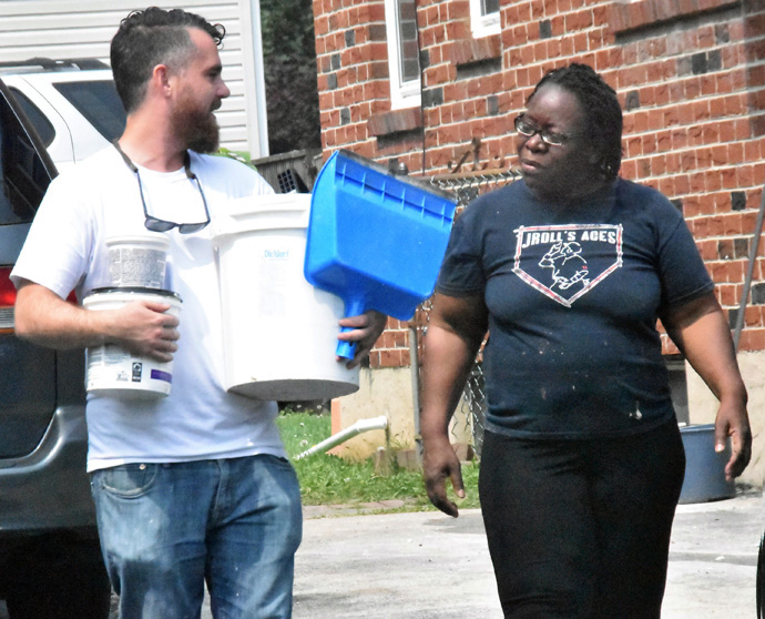 Daniel Jeffers, construction project manager for Project Restoration, speaks with Brenda Wyatt of Collingdale, Pennsylvania, as he carries supplies to her home. Wyatt’s home suffered flood damage in 2021 from Hurricane Ida, and Project Restoration is helping her repair the damage. Photo by John Coleman, Eastern Pennsylvania Conference.