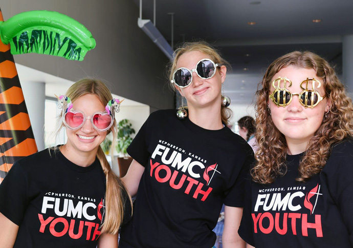Aparentemente, usar óculos cor-de-rosa pode ser uma coisa boa. Jovens da Primeira Igreja Metodista Unida em McPherson, Kansas, fazem uma pausa para uma foto divertida durante a Juventude 2023, em Daytona Beach, Flórida. 