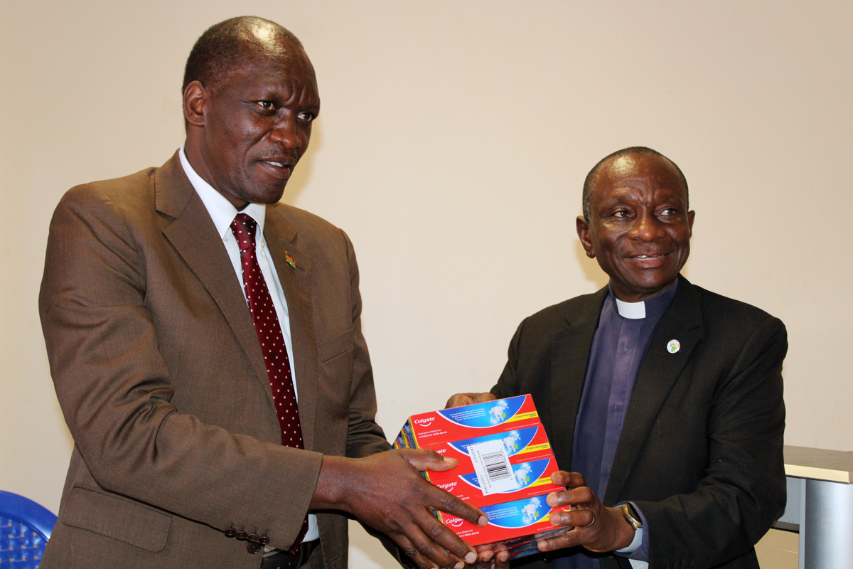The Rev. Alan Masimba Gurupira (right), administrative assistant to the bishop in Zimbabwe, hands over donations to retired Maj. Gen. Elias H. M. Mpaso, Malawian vice ambassador in Zimbabwe, during a ceremony at the Zimbabwe West Conference head office in Harare. The goods were collected by Zimbabwean United Methodists for Cyclone Freddy survivors in Malawi. Photo by Kudzai Chingwe, UM News. 
