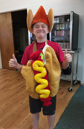 Chase Rhynehardt, a member of Gethsemane United Methodist Church in Greensboro, N.C., frequently wears a hot dog costume and waves people into the entrance of the church on Hot Dog Saturday, which happens every two weeks. Photo courtesy of Gethsemane United Methodist Church.