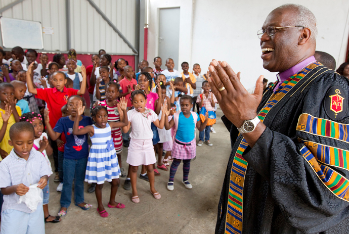 United Methodist Bishop Warner H. Brown (right) gives thanks for a presentation in his honor by the children of Central United Methodist Church in Luanda, Angola. After his election to the episcopacy in 2000, he and fellow newly elected bishops from Angola created a partnership where churches from Brown’s episcopal area would provide salary support for clergy in East Angola. Their congregations often couldn’t afford to pay their full salary. 2012 file photo by Mike DuBose, UM News.