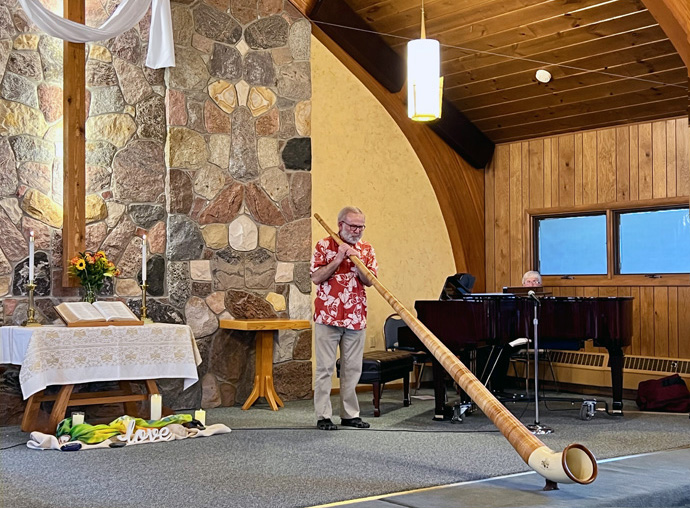 Paul Watson demonstrates the alpine horn as part of the Music for Missions fundraiser hosted by Columbia Falls United Methodist Church in Columbia Falls, Mont., to benefit the East Angola partnership. In addition to ongoing pastor salary support, the legacy Yellowstone and Rocky Mountain conferences helped to create an agricultural program at Quéssua Mission in the East Angola Conference. Photo courtesy of the Rev. Jared Stine.