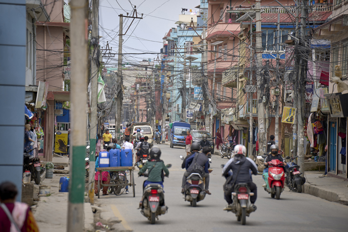 Motorcyclists traverse a street in Lalitpur, Nepal, May 25. The Rev. Jeewan Lama, pastor of  Hebron United Methodist Church, says Christianity spreads more easily among the poor, who find an acceptance in the church not offered to them in the larger Nepalese society. Photo by Paul Jeffrey, UM News.