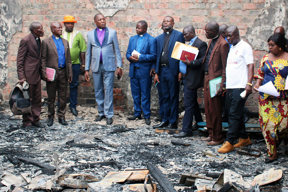 United Methodist Bishop Daniel Lunge (fourth from left) stands in front of the ruins following a fire at the Institut Supérieur Pédagogique de Wembonyama’s computer laboratory in Central Congo. The fire had a major impact on the activities of the United Methodist school, which specializes in teacher training. Photo by François Omanyondo, UM News.