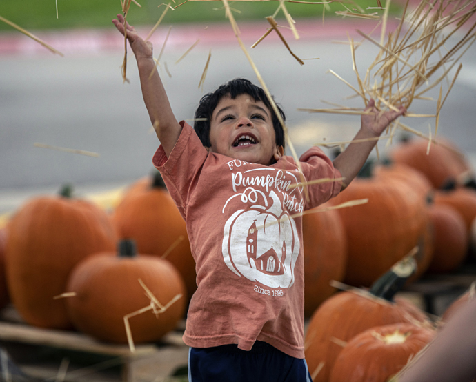 Happiness is having straw to fling at the First United Methodist Church of Georgetown, Texas, pumpkin patch. Photo by Andy Sharp.