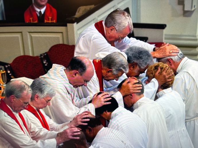 Bishop William Boyd Grove (top right) lays hands on Bishop Thomas Bickerton (far right, kneeling) during the latter’s consecration at the Northeastern Jurisdictional Conference, July 16, 2004. Bickerton, current president of the Council of Bishops, and Grove were colleagues and friends for more than 40 years. Grove died on Oct 27 at age 94. Photo courtesy of the West Virginia Conference.