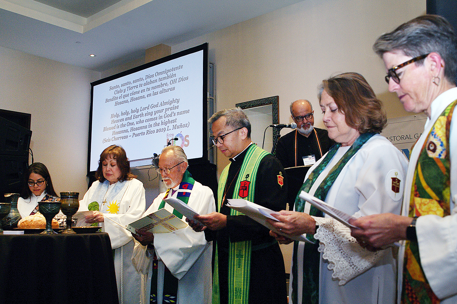 Members of the episcopacy of The United Methodist Church presided over the ceremony of the sacrament of Holy Communion during worship at Entre Nos. From left to right: Deaconess Patricia Bonilla, Northern Illinois Conference; Bishop Minerva Carcaño, California-Nevada Conference; Bishop Elías Galván, executive director of MARCHA; Bishop Carlo Rapanut, Desert Southwest Conference; Bishop Dottie Escobedo-Frank, California-Pacific Conference; and Bishop Sally Dyck, ecumenical officer of the Council of Bishops. Photo by the Rev. Gustavo Vasquez, UM News.