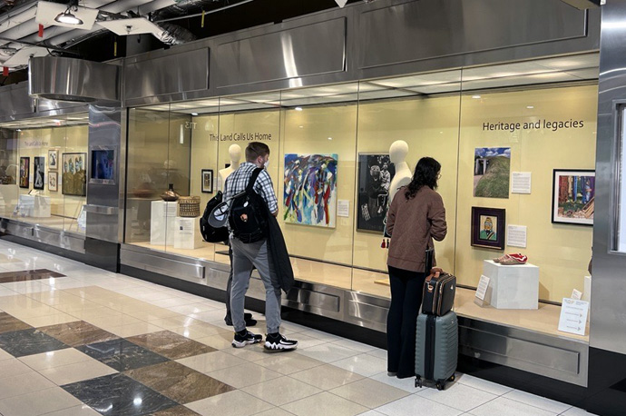 Visitors view the newly installed works of “This Land Calls Us Home,” on view at Concourse T North, near gates T12-15 at Hartsfield-Jackson Atlanta International Airport in Atlanta. Photo by Dan Curran for Global Ministries.