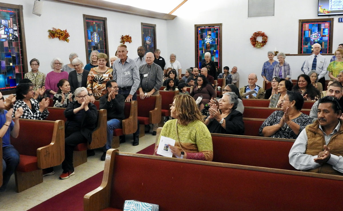 Members of La Trinidad United Methodist Church applaud as Walnut Springs United Methodist members stand during a Nov. 19 worship service in Seguin, Texas. La Trinidad has given over its fellowship hall to the Walnut Springs group, which consists of people who chose to remain United Methodist after their church disaffiliated. La Trinidad and Walnut Springs worship together on special occasions. Photo by Sam Hodges, UM News.