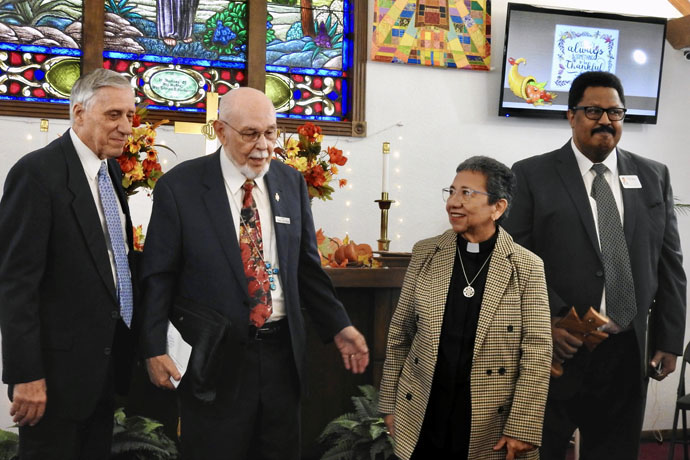 The Rev. Ron Welborn, Retired Bishop Joel Martinez, the Rev. Nohemí Ramirez and the Rev. Marcus Freeman, a Rio Texas Conference district superintendent, begin to exit the La Trinidad United Methodist Church after worship on Nov. 19. La Trinidad, a historic Hispanic church in Seguin, Texas, has provided meeting space and crucial support to Walnut Springs United Methodist, a new church formed of people who stayed United Methodist after their Seguin church disaffiliated. Welborn leads the new group and Ramirez leads La Trinidad. Photo by Sam Hodges, UM News. 