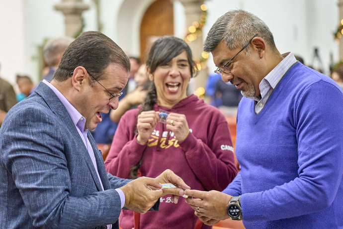 United Methodist Bishop Héctor A. Burgos-Núñez (left) exchanges souvenir lapel pins with Methodist Bishop Rodolfo Edgar Rivera de la Rosa, head of North-Central Annual Conference in Mexico, on Nov. 30, 2023, during a conference in Mexico City observing the 150th anniversary of the founding of the Methodist Church of Mexico. Observing the exchange is the Rev. Cynthia Carillo, the spouse of Bishop Rivera de la Rosa. Photo by Paul Jeffrey, UM News.