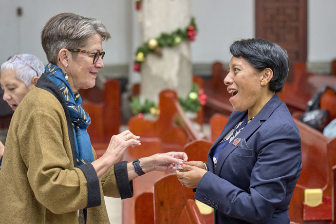 United Methodist Bishop Sally Dyck (left) exchanges lapel pins with the Rev. Zabdiel Campos, a Methodist minister and superintendent of the Valle de Anáhuac District, on Nov. 30, 2023, during a conference in Mexico City observing the 150th anniversary of the founding of the Methodist Church of Mexico. Bishop Dyck, who is retired but serves as the ecumenical officer of the United Methodist Council of Bishops, was an invited guest. Photo by Paul Jeffrey, UM News.