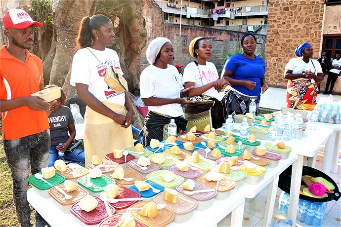 Jovens Adultos organizam parte dos alimentos na mesa para os beneficiários. Malanje, foto de João Nhanga.