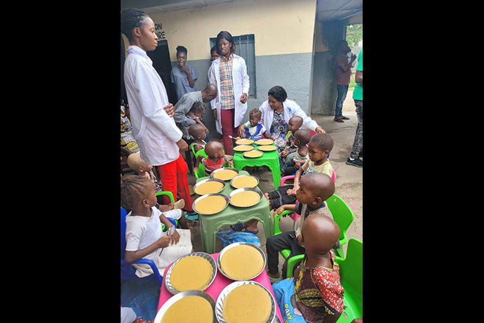 Des enfants reçoivent un repas de porridge au Centre Hospitalier Méthodiste de Mangobo à Kisangani, au Congo, tandis que le personnel les surveille. En 2023, l'Église Méthodiste Unie a soigné plus de 2 300 enfants malnutris dans la région, dont 771 souffrant de malnutrition aiguë. Photo avec l'aimable autorisation du département de la santé de l'Église Méthodiste Unie au Congo Est. 