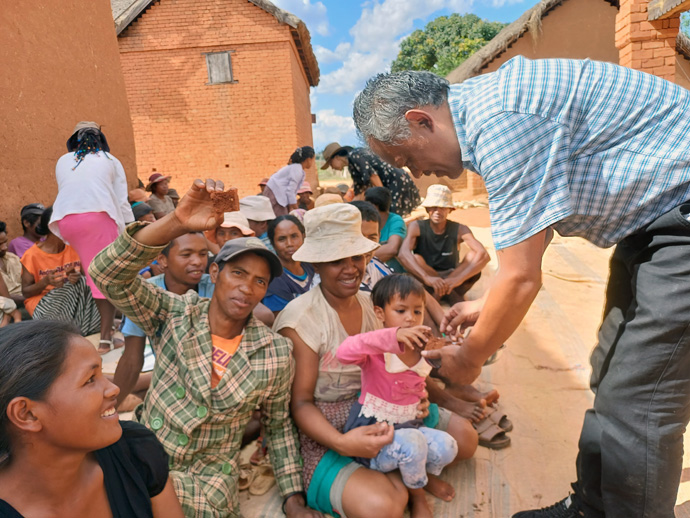 Jean Aime Ratovohery helps distribute a treat to the people of Faratanjona, a remote village in Madagascar. Ratovohery, lay preacher at Ambodifasika United Methodist Church, and members of his congregation visited the village to deliver food and share the gospel. Photo by Esdras Rakotoarivony, UM News.