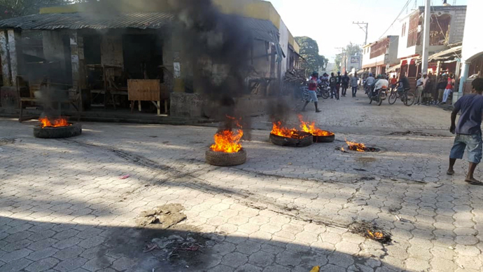 Flaming tires can be seen in the streets of Hinche in the center of Haiti on Feb. 11, 2019. Protests that began in cities throughout Haiti on July 7, 2018, in response to increased fuel prices have continued for over 5 years making mission work there difficult. File photo by R. Ambroise, Voice of America, courtesy of Wikimedia Commons.