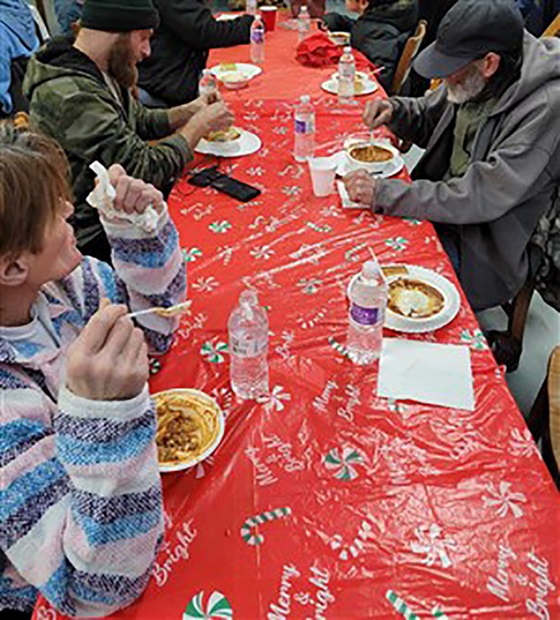 Huéspedes del refugio comparten una comida en la Iglesia Metodista Unida Avenida Magnolia. Foto cortesía de Lakisha Johnson.
