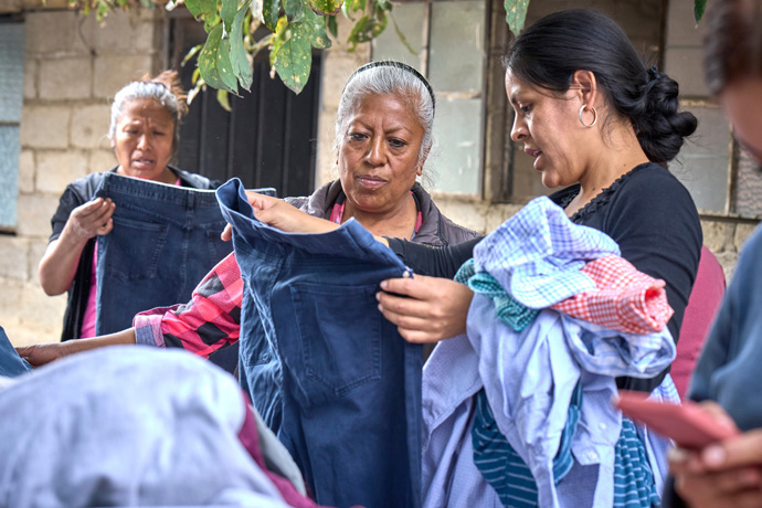 Residents of San Andrés Tlalamac, Mexico, browse donated clothes sold to raise funds for a clinic in the village run by the Methodist Church of Mexico. The clinic was built by volunteer groups from the United States, but the local community has had difficulty keeping it open. The project has received support from the United Methodist Board of Global Ministries. Photo by the Rev. Paul Jeffrey, UM News.
