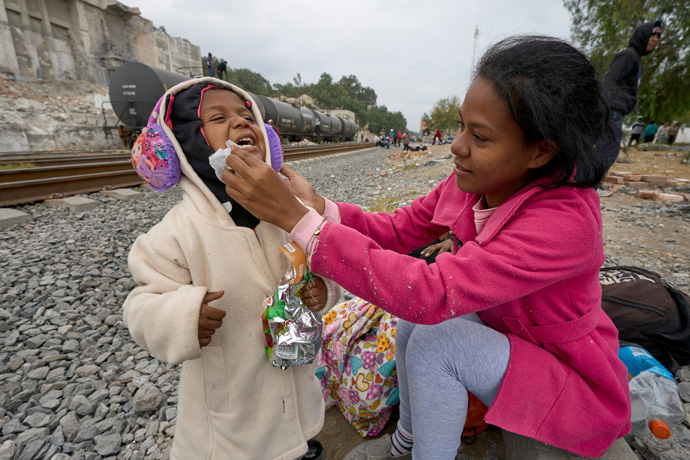 After spending the night sleeping beside the railroad tracks in Apaxco, Mexico, Mari Angeli cleans the face of her 3-year old daughter, Ari. They are from Venezuela, and have been traveling for a month. They received support in the town from a shelter run by the Methodist Church of Mexico, with support from the United Methodist Committee on Relief. Photo by the Rev. Paul Jeffrey, UM News.