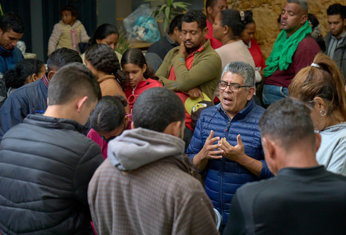 Bishop Agustín Altamirano Ramos prays with migrants inside the Center for Attention to Migrants, a shelter in Apaxco, Mexico, run by the Methodist Church of Mexico. Altamirano heads the Mexico City-based Mexico Annual Conference of the Methodist Church of Mexico. Photo by the Rev. Paul Jeffrey, UM News.