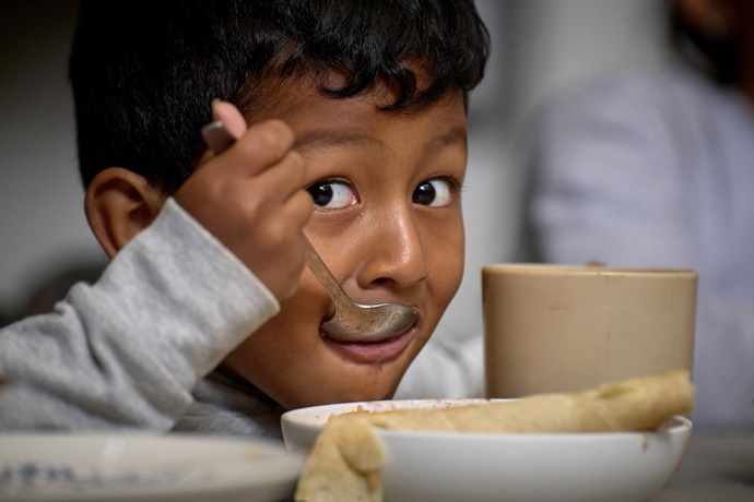 Jaden José Rivas Romero, a 4-year-old boy from Tegucigalpa, Honduras, eats a meal in the Center for Attention to Migrants, a shelter housed in the Holy Trinity Methodist Church in Apaxco, Mexico. Traveling with his parents and a sibling, the boy has been on the road for a month. They left two siblings behind in Honduras, where rising gang violence convinced the family to flee. Photo by the Rev. Paul Jeffrey, UM News.
