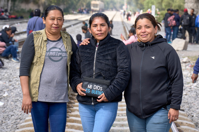 Kimber Lopez (left) and Janet Gonzalez (center), both from Guatemala, pose on the railroad tracks in Apaxco, Mexico, with Eliz Escobar from Venezuela. The three women, who are traveling together for safety, are waiting with other migrants for a northbound freight train to stop so they can climb aboard. They received assistance in the town from a shelter run by the Methodist Church of Mexico, with support from the United Methodist Committee on Relief. Photo by the Rev. Paul Jeffrey, UM News.