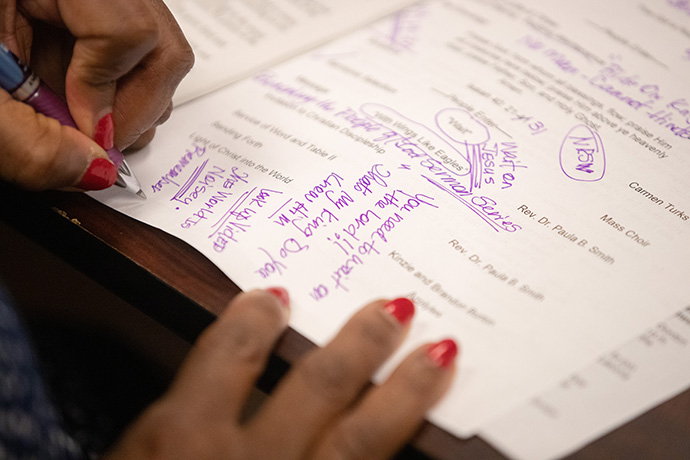 Tina Boone makes notes on her copy of the order of worship while hosting dial-in worship at Gordon Memorial United Methodist Church in Nashville, Tenn. Photo by Mike DuBose, UM News.