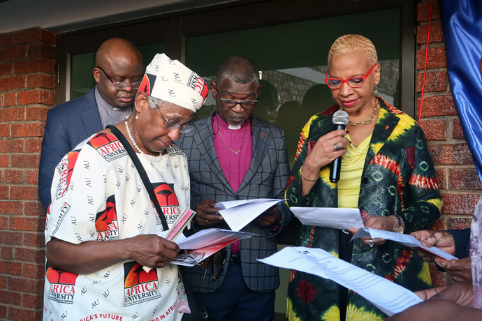 Maggie Jackson (left) of the East Ohio Conference, Bishop Tracy S. Malone (right), East Ohio Episcopal Area, Bishop Mande Muyombo (back left), Africa University board chair, and Bishop Gaspar Domingos (back right), Africa University chancellor, read documents during the official opening of a new residential hall at the school, which was built by the conference. Jackson was one of the co-chairs for the Teach-Reach-Bless campaign. Photo by Eveline Chikwanah, UM News.