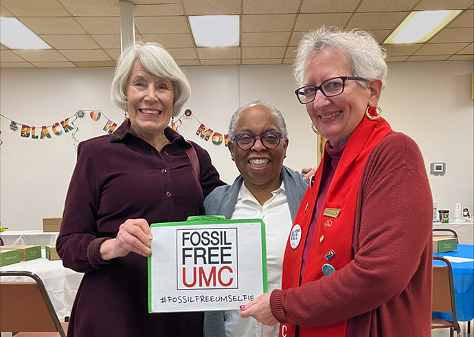 Judy Smith, Cynthia Taylor and Sherie Koob of the Baltimore-Washington Conference show support for Fossil Free UMC, a grassroots caucus supporting divestment of fossil fuel company stocks owned by United Methodist institutions. Photo by Mike Koob. 