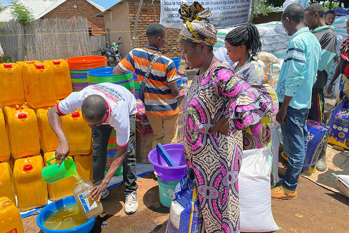 Des femmes attendent de l'huile végétale dans le camp de déplacés de Malicha à Fizi, au Congo. L'Église Méthodiste Unie a distribué 74 tonnes de fournitures aux survivants des deux incendies qui ont ravagé le camp en août et en octobre. L'aide comprenait du riz, de la farine de maïs, du sel, du sucre, des haricots, du savon, des brosses à dents et bien plus encore. Photo gracieusement fournie par le Bureau de Gestion des Catastrophes de la Région Épiscopale du Congo Est.