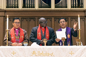 United Methodist Bishops bless the elements of Holy Communion during a world-wide worship service at First United Methodist Church in Charlotte, N.C., in the lead-up to the 2024 United Methodist General Conference. From left are Bishops Israel Maestrado Painit of the Philippines, John Wesley Yohanna of Nigeria and Rodolfo A. Juan of the Philippines. The gathering was coordinated by the Love Your Neighbor Coalition and the National Association of Filipino-American United Methodists. Photo by Mike DuBose, UM News.