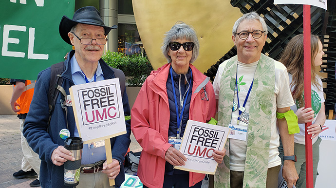 Jaydee Hanson (à gauche), l'Évêque Méthodiste à la retraite Hope Morgan Ward et le révérend Pat Watkins (à droite) participent à une manifestation organisée le 23 avril devant le siège de la Bank of America à Charlotte (Caroline du Nord). Fossil Free UMC s'est joint au plaidoyer pour que la banque cesse de soutenir financièrement les entreprises de combustibles fossiles. Le groupe de pression espère également que la Conférence Générale, qui se tient à Charlotte jusqu'au 3 mai, exigera des Institutions Méthodistes Unies qu'elles se désengagent des actions des entreprises de combustibles fossiles. Avec l'aimable autorisation de Fossil Free UMC.