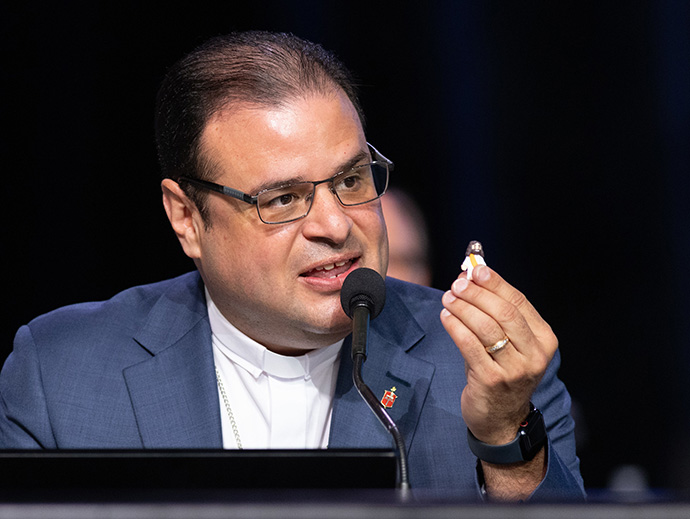 Bishop Héctor A. Burgos-Núñez holds a small Jesus figurine while reminding delegates to the United Methodist General Conference in Charlotte, N.C., that “Jesus is watching. Photo by Mike DuBose, UM News.