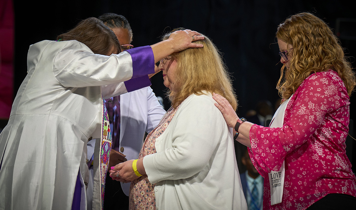 Lori Sluder is consecrated a deaconess by Bishop Karen Oliveto on April 29 during the United Methodist General Conference in Charlotte, N.C. Assisting her is Megan Hale (right), the executive for the Candidacy Office of Deaconess and Home Missioner of United Women in Faith. Sluder serves as executive assistant to the bishop of the Holston Conference. Photo by Paul Jeffrey, UM News.