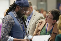 Delegates Jay Williams (left), New England Conference, and Allie Scott, Wisconsin Conference, look over the day’s agenda before the start of the United Methodist General Conference plenary session on April 30 in Charlotte, N.C. Photo by Larry McCormack, UM News.