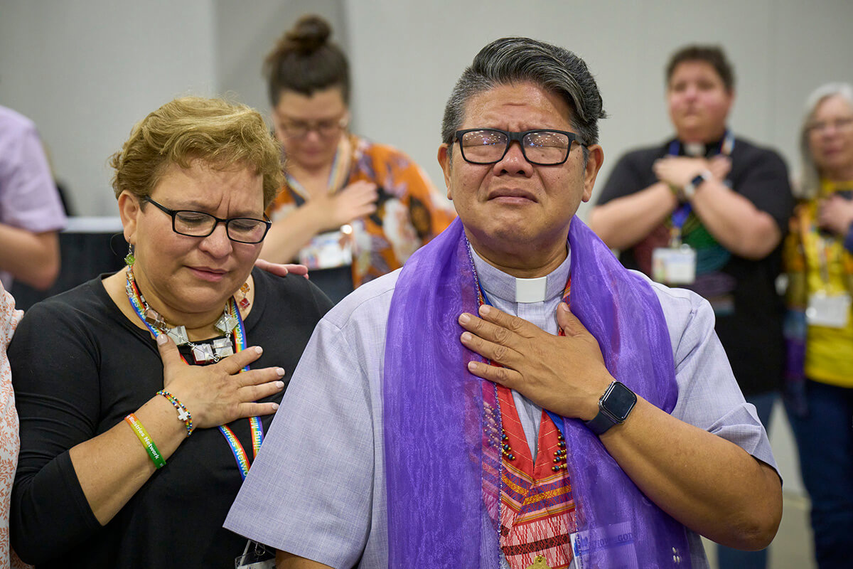 The Rev. Izzy Alvaran and others pray together on May 1 after the United Methodist General Conference, meeting in Charlotte, N.C., voted to remove the denomination's ban on the ordination of clergy who are "self-avowed practicing homosexuals" — a prohibition that dated to 1984. Photo by Paul Jeffrey, UM News.