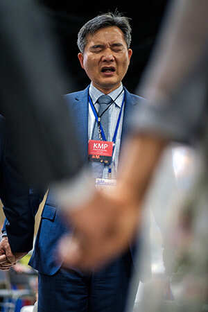 The Rev. Chang Min Lee, pastor of Los Angeles Korean United Methodist Church and president of the Korean Association of the United Methodist Church, leads a prayer after he announces that Korean churches will support 140 missionaries through the General Board of Global Ministries of The United Methodist Church on May 2 during the United Methodist General Conference in Charlotte, N.C. Photo by Corbin Payne, Greater New Jersey Conference. 