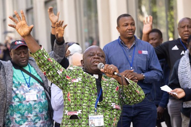 O Reverendo Jerry Kulah, da Libéria, lidera um protesto em 2 de maio em frente ao Centro de Convenções de Charlotte, em Charlotte, N.C., depois que os delegados da Conferência Geral apoiaram uma revisão dos Princípios Sociais que redefinem o casamento. Kulah e outros africanos presentes apoiam as visões tradicionais do casamento. Foto de Mike DuBose, Notícias da MU.
