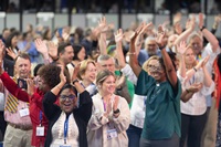 Delegados/as, visitantes y personal de la Conferencia General Metodista Unida reunida en Charlotte, Carolina del Norte bailan en los pasillos después del culto matutino del último día de la conferencia. Foto de Mike DuBose, Noticias MU.