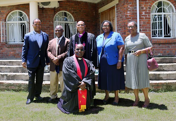 The Rev. Ellison Kamupira kneels before Bishop Eben K. Nhiwatiwa and family friends after his honorary ordination on Dec.13, 2020, in Harare, Zimbabwe. Photo by Eveline Chikwanah, UM News.
