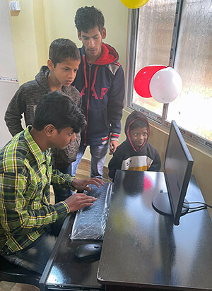 Young people at an AIDS orphanage in Kokata, India, test out computers in new lab provided by the Center for Health and Hope, which supports and advocates for persons infected and affected by HIV and AIDS around the world. The center is an ecumenical nonprofit founded and led by retired United Methodist pastor the Rev. Donald E. Messer. Photo by the Rev. Donald E. Messer.