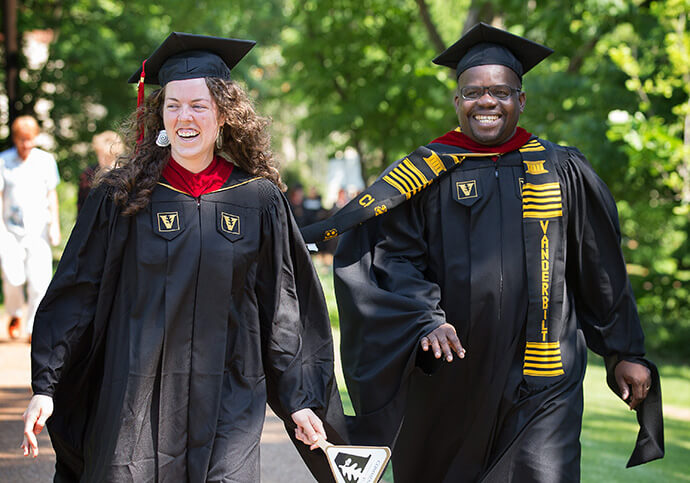 Isaac Broune e a colega de classe Keller Hawkins caminham para a cerimônia de formatura na Vanderbilt Divinity School em Nashville, Tennessee, em 2018. Foto de arquivo de Mike DuBose, Notícias MU. 