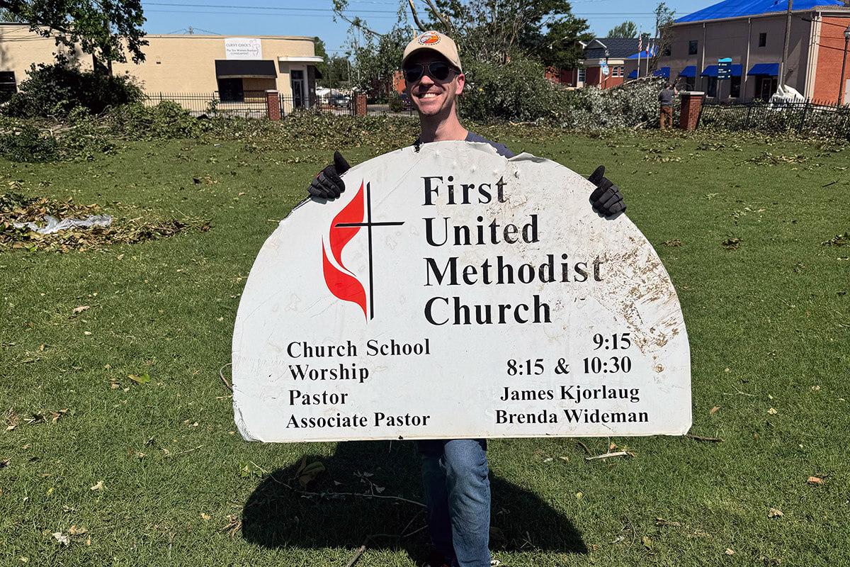 The Rev. James Kjorlaug, senior pastor of First United Methodist Church in Rogers, Ark., holds a church sign that came dislodged following storms that struck the town May 26. Photo courtesy of the Rev. James Kjorlaug.