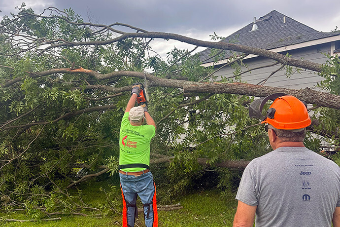 United Methodist volunteers remove downed trees in Claremont, Okla. Teams from Claremore’s Grace United Methodist Church and from Tahlequah United Methodist, about an hour away, have been helping since a tornado hit Claremont late on May 25. Photo courtesy of the Rev. Tim McHugh.