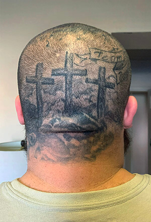Among Jeremiah Bowden’s many tattoos are the three crosses symbolizing Jesus’ crucifixion across the back of his head. Bowden, who said he didn’t understand the concept of God as a child, is now considering becoming a pastor. Photo by Joey Butler, UM News.