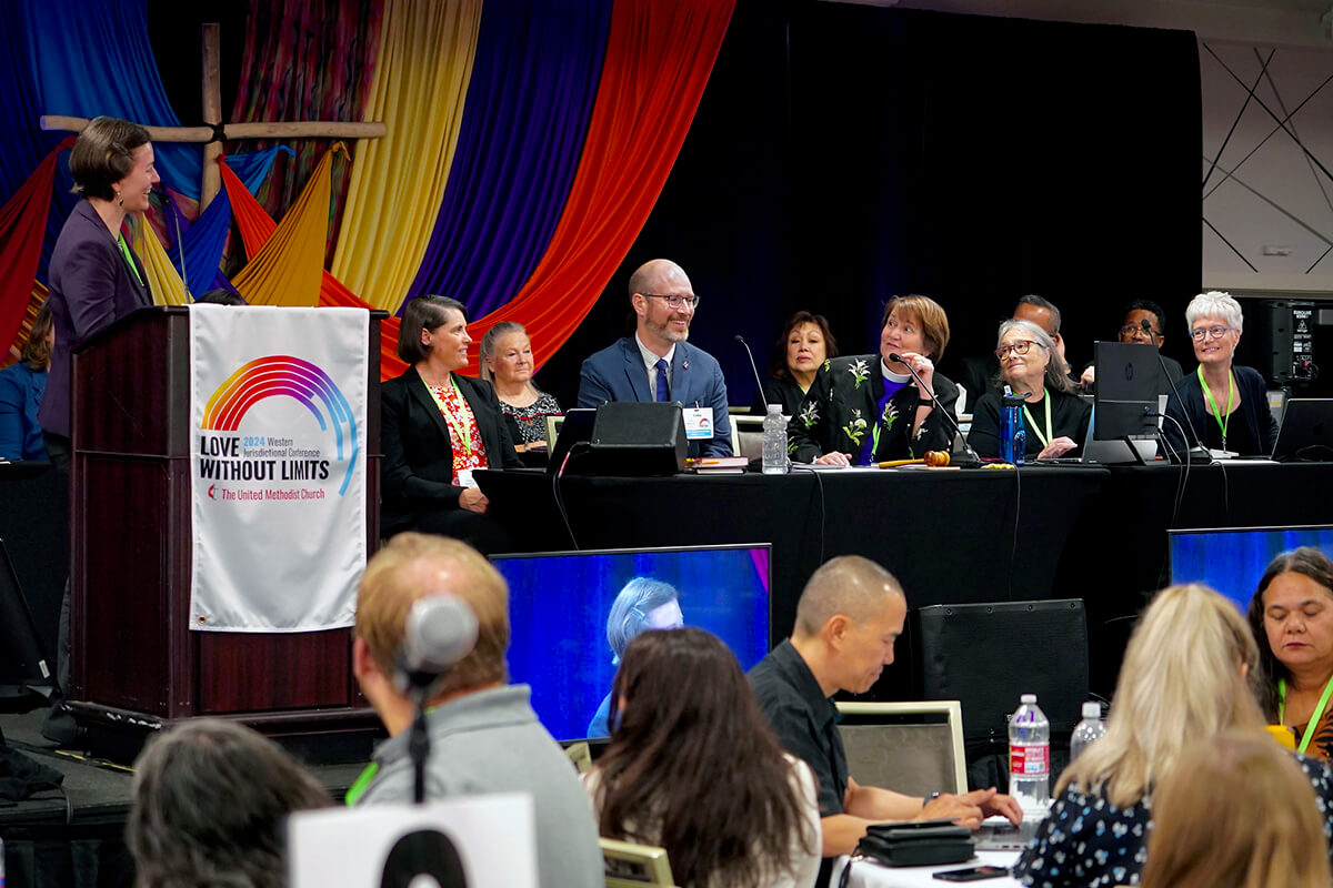 Bishop Karen Oliveto (center) speaks with Emily Allen (left), a member of the Western Jurisdiction Committee on Episcopacy, as she introduces the next step in the episcopal election process at the 2024 Western Jurisdictional Conference on July 11 at Centennial Hotel in Spokane, Wash. The Western Jurisdiction is the only U.S. jurisdictional conference holding episcopal elections this year. Photo by Patrick Scriven, Western Jurisdiction.
